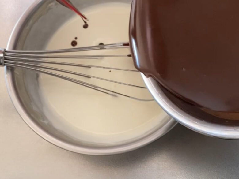 5分立てに泡立てた生クリームにダークチョコレートと牛乳を混ぜ合わせた生地を加えている様子