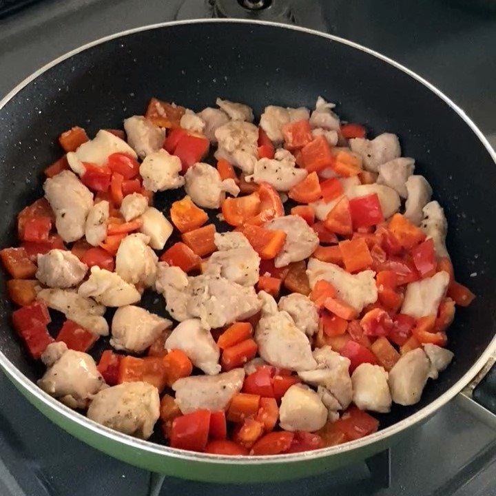フライパンで炒めている鶏もも肉と赤パプリカ-2