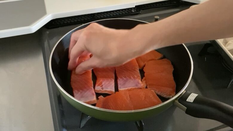 フライパンで生鮭を焼いている様子