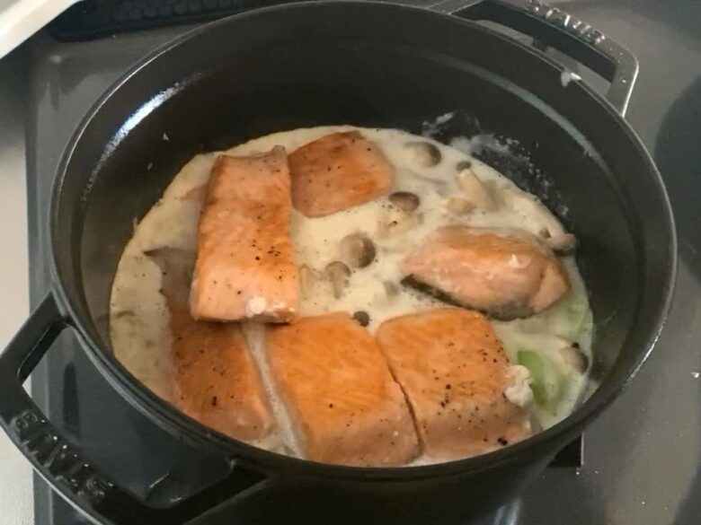 ストウブ鍋で煮込んでいる秋鮭（生鮭）としめじと小松菜のクリーム煮