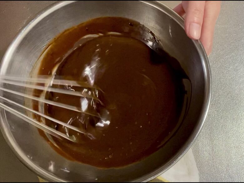 溶かしたチョコレートとバターをホイッパーで混ぜている様子