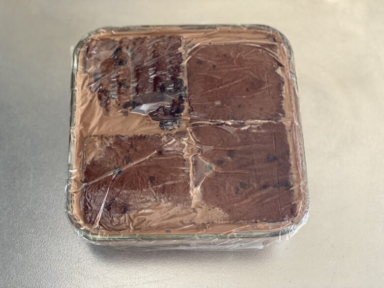 イワキ保存容器に流し入れた濃厚チョコレートムースケーキの生地にココアの台湾カステラをのせた様子