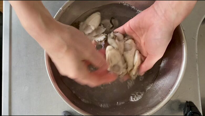 塩水で牡蠣の下処理をしている様子