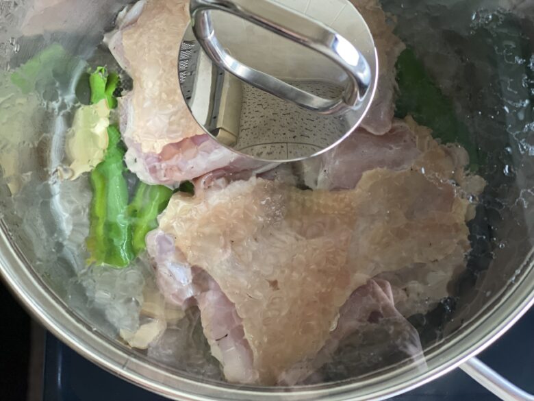 ステンレス鍋でふたをして蒸している鶏もも肉