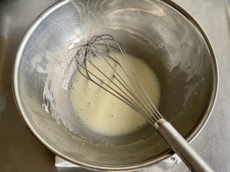 ステンレスボウルに入れたユウキ食品 杏仁霜（きょうにんそう）を牛乳で混ぜ溶かしたところ