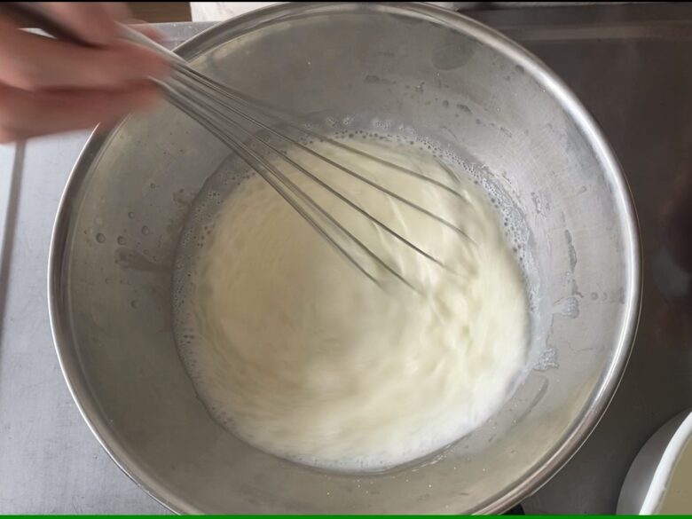 ステンレスボウルに入れたユウキ食品 杏仁霜（きょうにんそう）に牛乳を加えて混ぜているところ