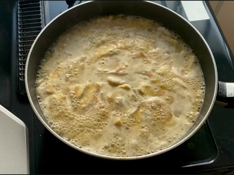 ラクサのスープをフライパンで煮立てているところ