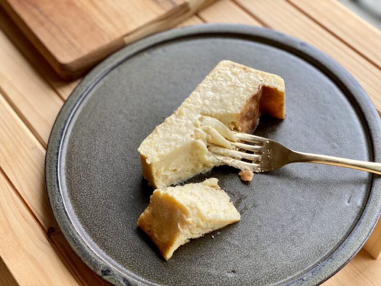 金色のフォークで崩したパイナップルのベイクドチーズケーキ
