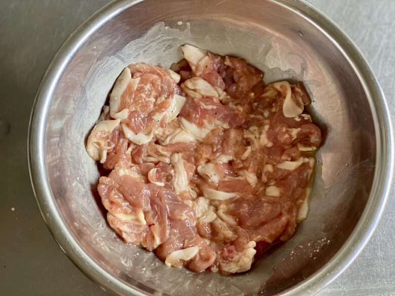 ステンレスボウルに入れて下味をつけた薄切り豚肉