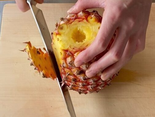 台湾パイナップルの皮を包丁で切っている様子-1